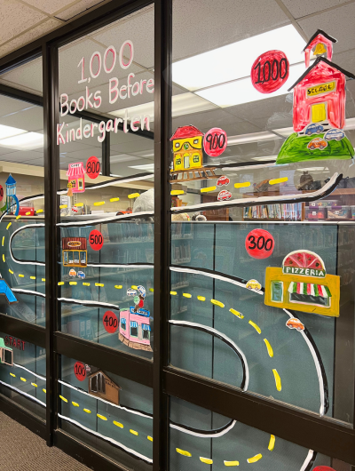 Image of the 1,000 Books before Kindergarten mural in the Children's Room depicting a road with buildings from around Mt Pleasant.